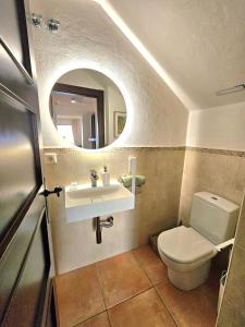 a bathroom with a toilet and a sink and a mirror at Sea View Chalet - Altea Hills in Altea +13 photos