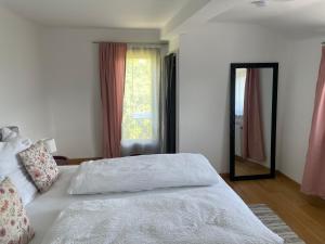 a bedroom with a white bed and a mirror at Pension Victoria in Millstatt +24 photos