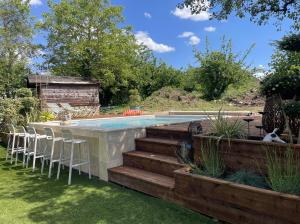 a swimming pool with some chairs and a yard at La longère du Ruet in Saint-Hilaire-Saint-Mesmin