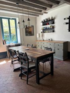 a dining room with a wooden table and chairs at La Vieille Demeure in Barbizon