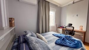 a bedroom with a bed with a chair and a window at SHB - Central Miramar Shopping Mall from the beach in Santos