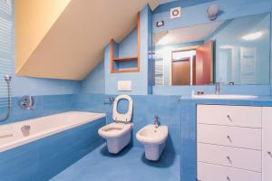 a blue bathroom with a toilet and a tub and a sink at Home Venice Apartments - Piazzale Roma in Venice