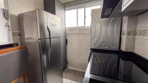 a kitchen with a stainless steel refrigerator and a window at SHB - Central Miramar Shopping Mall from the beach in Santos +35 photos
