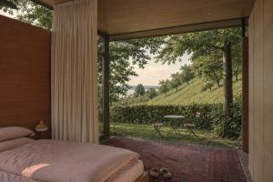 a bedroom with a bed and a large glass window at Haus am Felsen, Ferien in Vorarlberger Architektur in Bregenz