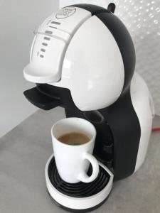 a coffee maker is making a cup of coffee at Central Boulevard Apartment in Šiauliai +11 photos