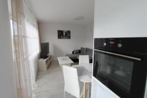 a living room with a kitchen and a living room with a tv at Central Boulevard Apartment in Šiauliai