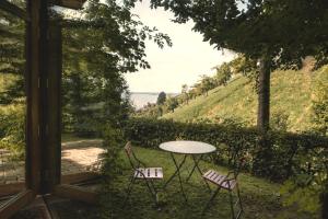 a table and two chairs in front of a window at Haus am Felsen, Ferien in Vorarlberger Architektur in Bregenz +8 photos