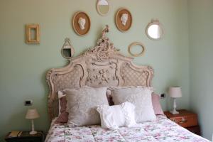 a bedroom with a large bed with pillows and mirrors at Casa Montalgallo in Lucignano