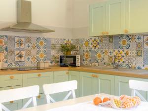 a kitchen with green cabinets and a table with fruit at Piazza 49 - HelloElba in Portoferraio +20 photos