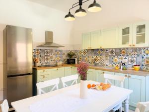 a kitchen with a white table and a refrigerator at Piazza 49 - HelloElba in Portoferraio