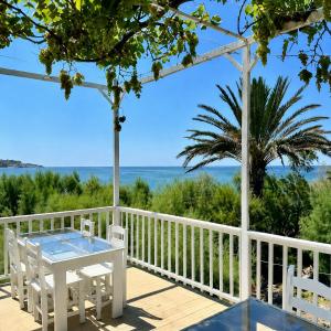 a deck with a table and chairs and the ocean at Riviera Beach Bungalows in Kyrenia