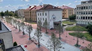a building with a lot of trees in a city at Central Boulevard Apartment in Šiauliai