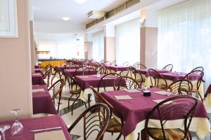 a row of tables and chairs with purple table cloth at Hotel Milord in Cesenatico