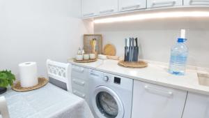 a white laundry room with a washing machine at Stone House Perast in Kotor