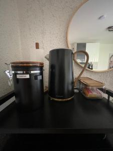 a black coffee pot sitting on a counter in front of a mirror at Grimm Apartment 4 in Kassel