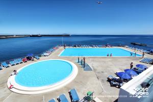 a large swimming pool next to a body of water at O Marinheiro 15A in Caniçal