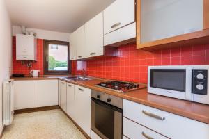 a kitchen with white cabinets and a microwave at Home Venice Apartments - Piazzale Roma in Venice