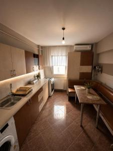 a small kitchen with a sink and a table at Apartament Central in Moineşti