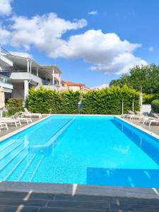 a swimming pool with blue water in front of a building at Luxury Suite Gala in Nikiti
