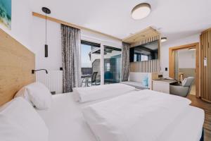 a hotel room with two beds and a desk at Hotel Alpenblick Attersee Superior in Attersee am Attersee +105 photos