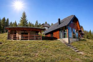 a house on a hill with the sun in the sky at Brvnara Tarin osmeh - u srcu Nacionalnog parka Tara in Sekulić 