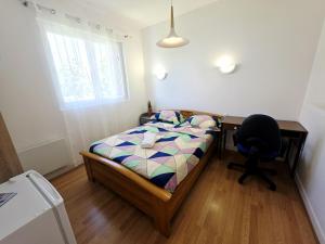a bedroom with a bed and a desk and a chair at Chambre 1 in Toulouse