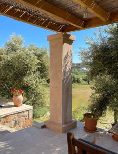 a patio with a pillar and a table with flowers at Studio Gaia in Kythira +1 photo
