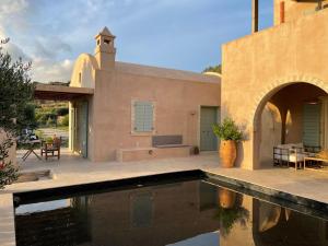 a house with a swimming pool in front of it at Studio Gaia in Kythira