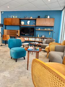 a waiting room with chairs and tables and a tv at Hôtel Neptune in Balaruc-les-Bains