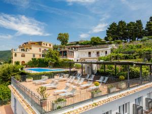 an apartment with a balcony with lounge chairs and a pool at Residence Le Villette in Ravello