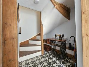 a room with a staircase and a table with a sewing machine at Katie's Cottage in Church Stretton +25 photos