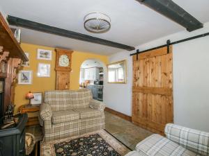 a living room with two chairs and a wooden door at Katie's Cottage in Church Stretton