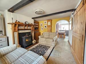 a living room with two couches and a fireplace at Katie's Cottage in Church Stretton