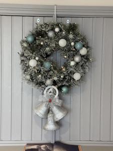 a christmas wreath with ornaments on a door at Crownhill Bay House in Plymouth +4 photos