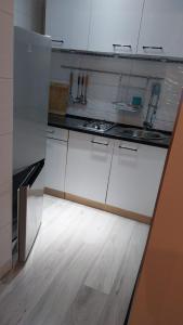 a kitchen with white cabinets and a wooden floor at Apartament u Amelki in Toruń