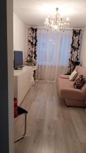 a living room with a couch and a chandelier at Apartament u Amelki in Toruń