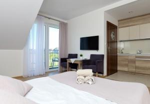 a hotel room with a bed and a kitchen and a table at Jerry Apartment in Jastrzębia Góra