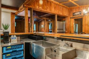 a kitchen with a stainless steel sink and wooden walls at Wildrest Hotel in Waynesville +135 photos