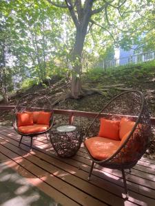 two chairs with orange pillows sitting on a deck at Sleeping Sailor in Camden