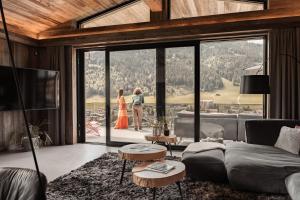 two people standing in a living room with a view at GOING TRIPLE A apartments EAST in Going am Wilden Kaiser