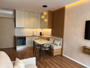 a kitchen and living room with a table and a couch at Palm Apartments Radhime in Vlorë