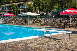 a swimming pool with umbrellas and a swimming pool at Camping Eurovil in Predore
