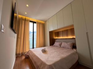 a bedroom with a bed and a large window at Palm Apartments Radhime in Vlorë +25 photos