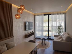 a living room with a couch and a table in a room at Palm Apartments Radhime in Vlorë