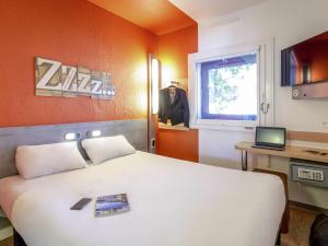 a bedroom with a bed and a desk and a window at Ibis Budget Marseille Timone in Marseille +47 photos