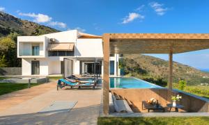 a villa with a swimming pool and a house at Mistral Suite Heated Pool in Georgioupoli