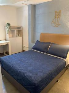 a bedroom with a bed with a blue comforter at Hotel Casa Lucca in Medellín