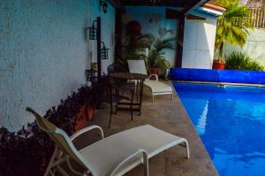 a patio with a table and chairs next to a swimming pool at Private Villa in Guadalajara with heated Swimming Pool in San Agustín