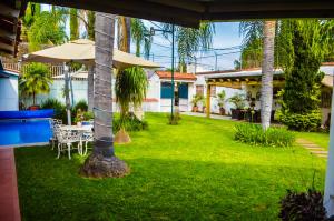 a garden with a table and an umbrella at Private Villa in Guadalajara with heated Swimming Pool in San Agustín