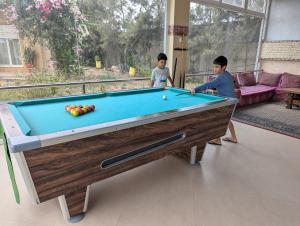 two children playing with a pool table in a room at Dar Beynana in Sidi Bibi